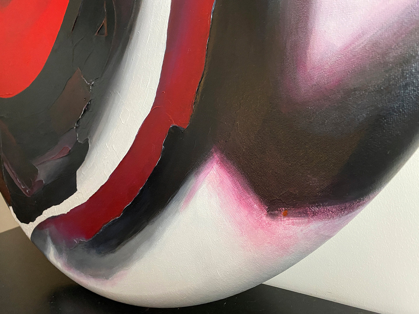 Abstract, acrylic and mixed-media painting close-up of the texture paste, red, black, grey, and white acrylic paint on round canvas focusing on the beautiful curved-edges 1