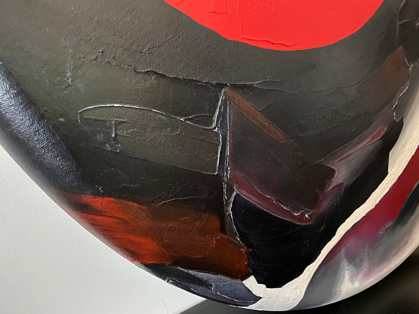 Abstract, acrylic and mixed-media painting close-up of the texture paste, red, black, grey, and white acrylic paint on round canvas focusing on the beautiful curved-edges 2