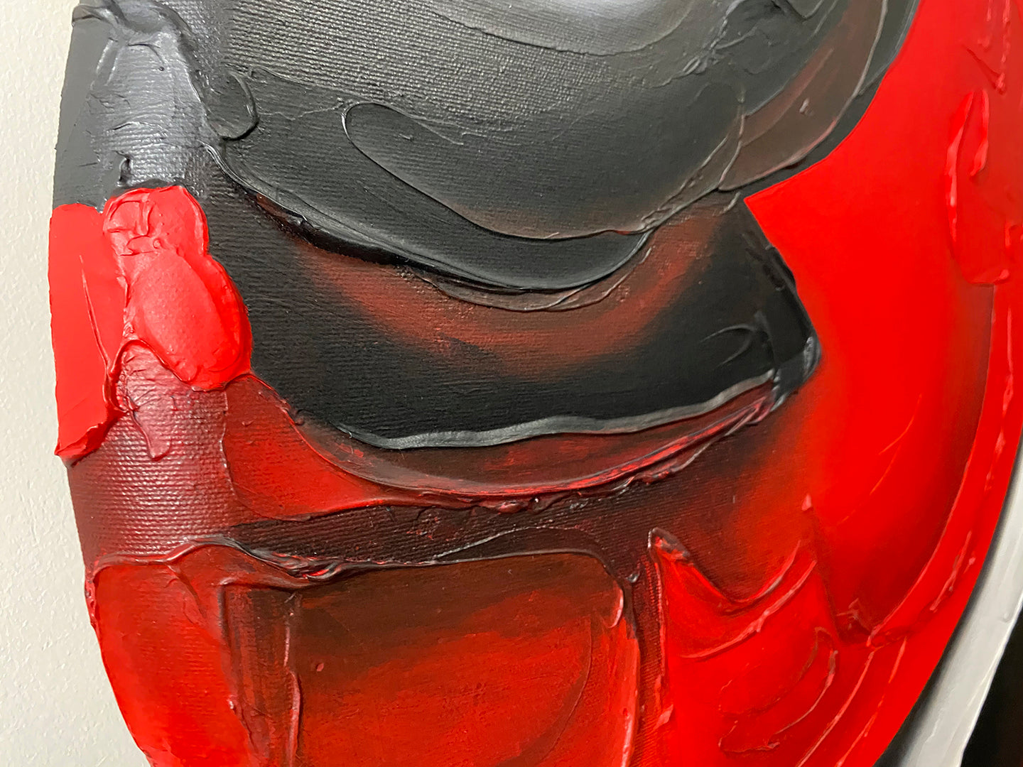 Abstract, acrylic and mixed-media painting close-up of the texture paste, red, black, grey, and white acrylic paint on round canvas focusing on the beautiful curved-edges 1