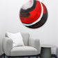Abstract, acrylic and mixed-media 30” print on a round canvas with curved-edges shown on a light living room wall above a grey chair