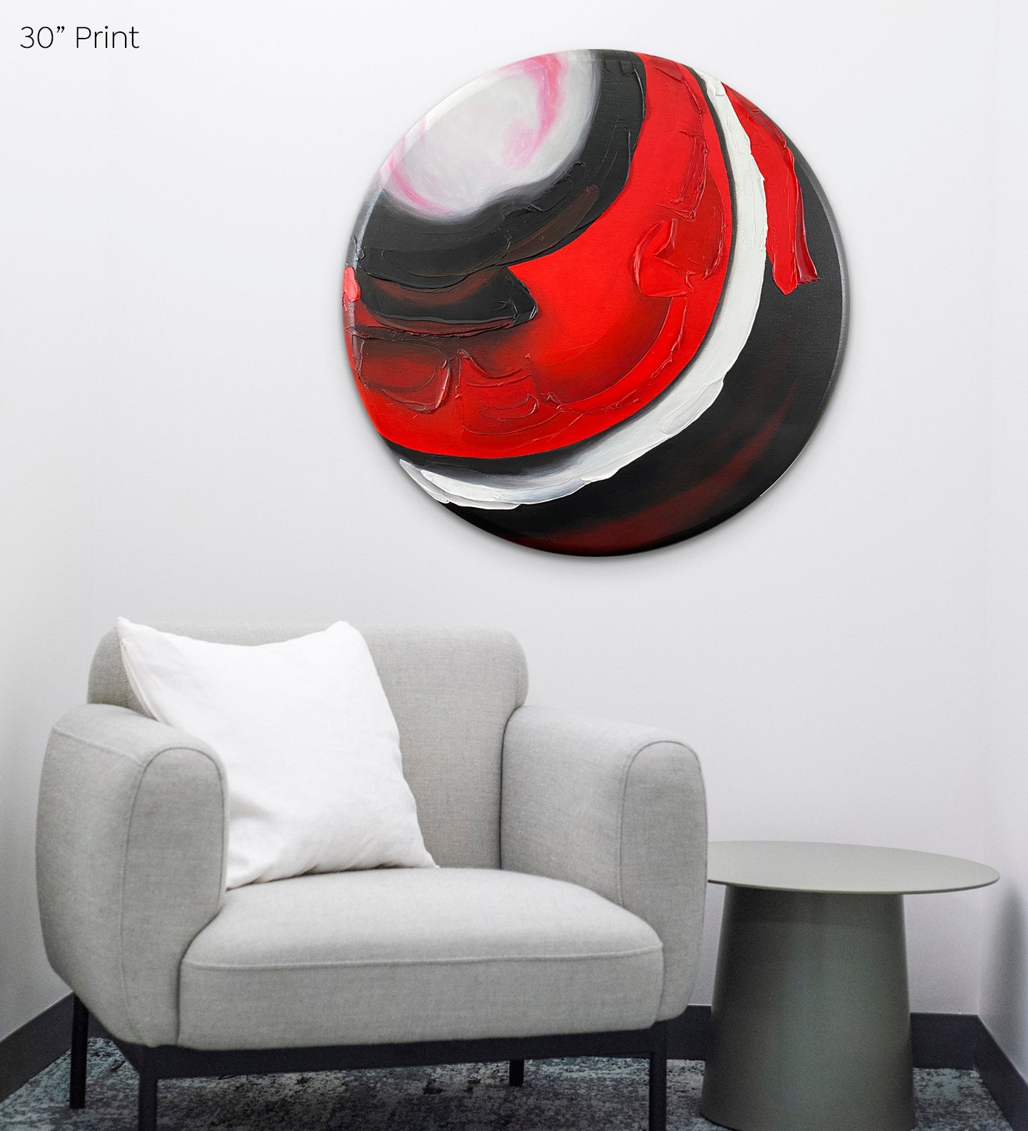 Abstract, acrylic and mixed-media 30” print on a round canvas with curved-edges shown on a light living room wall above a grey chair