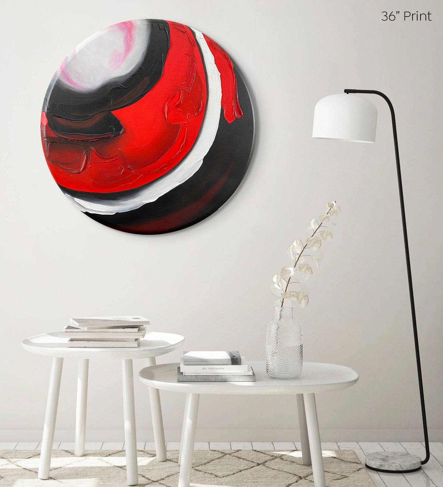 Abstract, acrylic and mixed-media 36” print on a round canvas with curved-edges shown on a pale wall above 2 round tables and a lamp.