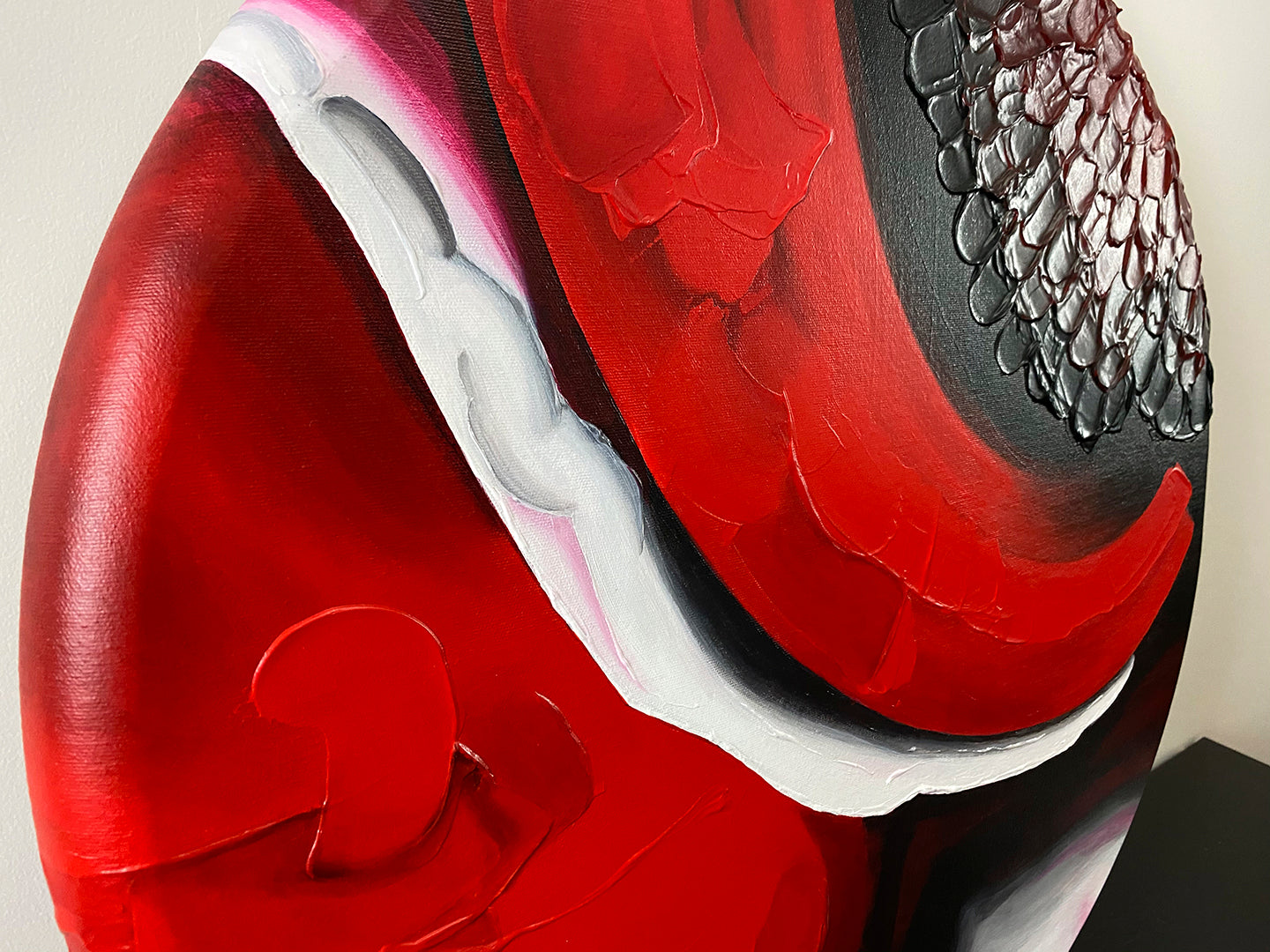 Abstract, acrylic and mixed-media painting close-up of the texture paste, red, black, grey, and white acrylic paint on round canvas focusing on the beautiful curved-edges 1
