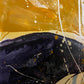 Abstract acrylic painting close-up 1 showing curved-edge of canvase: gold, yellows, phthalo-blue, purple-grey and white