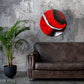 Abstract, acrylic and mixed-media 24” original or print on a round canvas with curved-edges shown on a dark grey, textured wall above a leather couch and plant.
