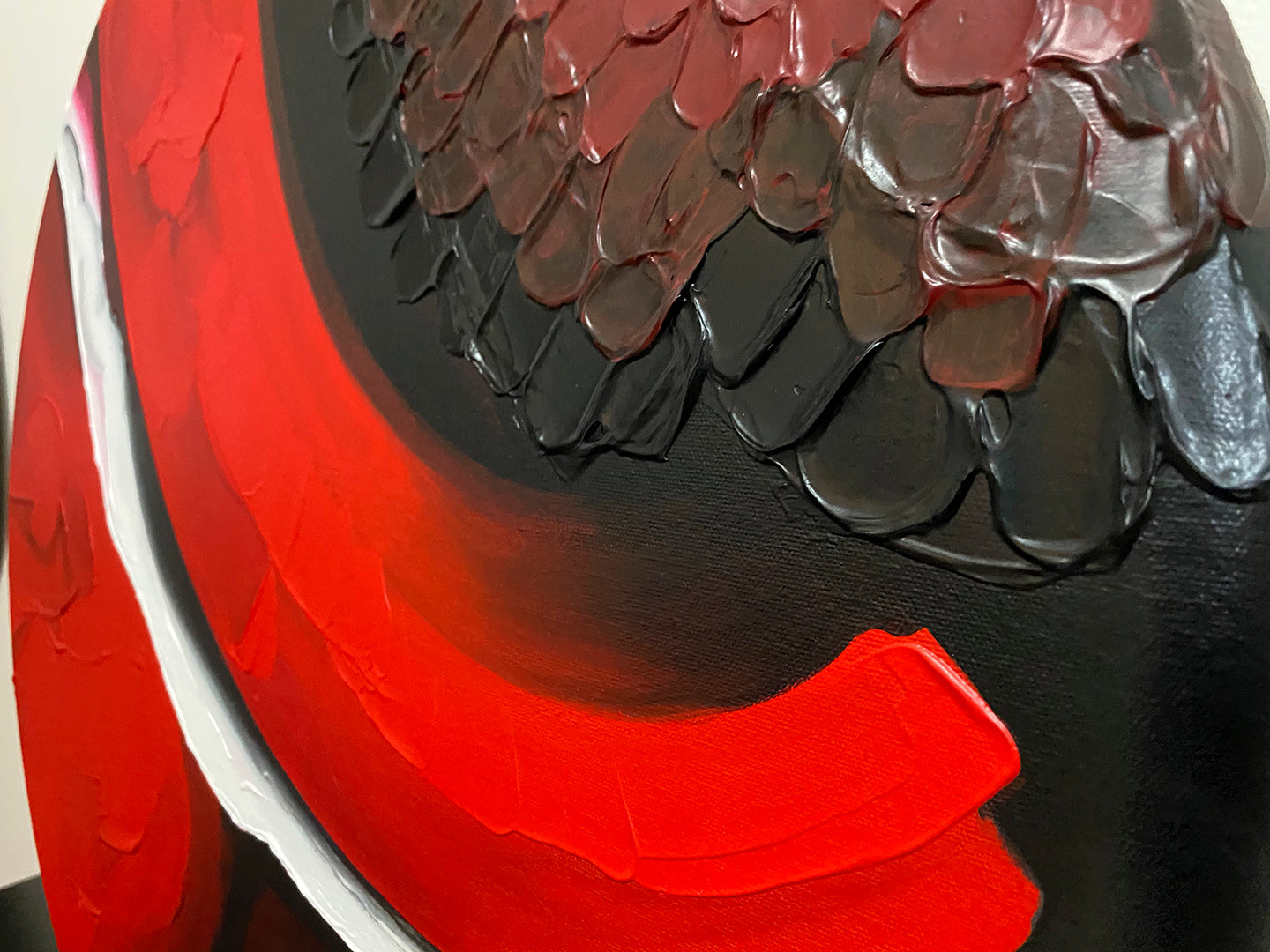 Abstract, acrylic and mixed-media painting close-up of the texture paste, red, black, grey, and white acrylic paint on round canvas focusing on the beautiful curved-edges 2
