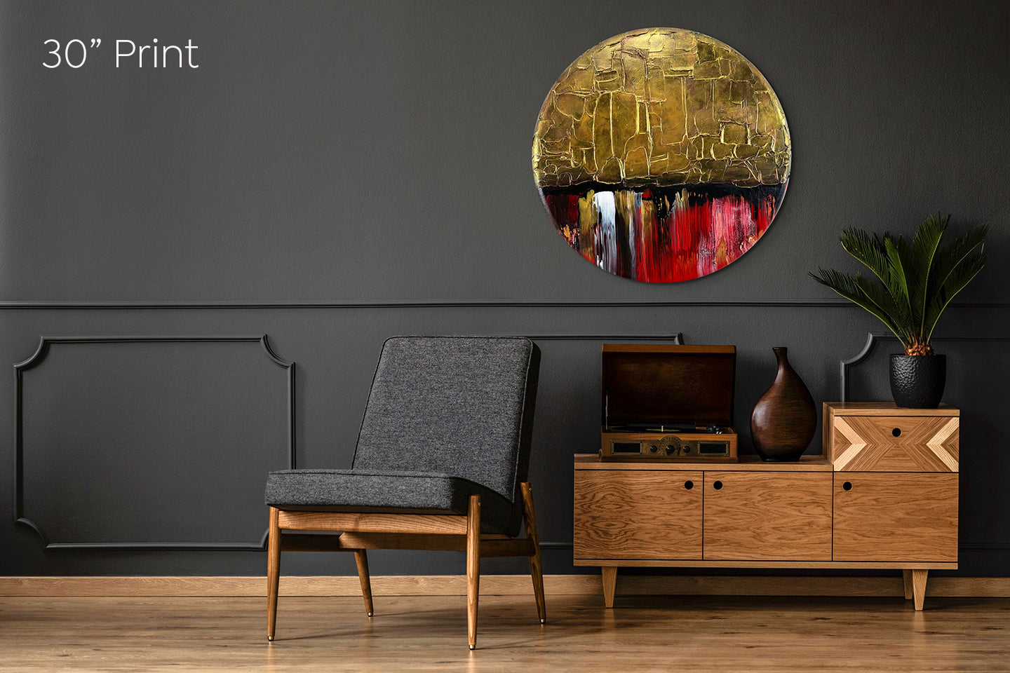 Abstract, acrylic and mixed-media painting on a round canvas with curved-edges shown on a dark grey living room wall above a chair and side-table