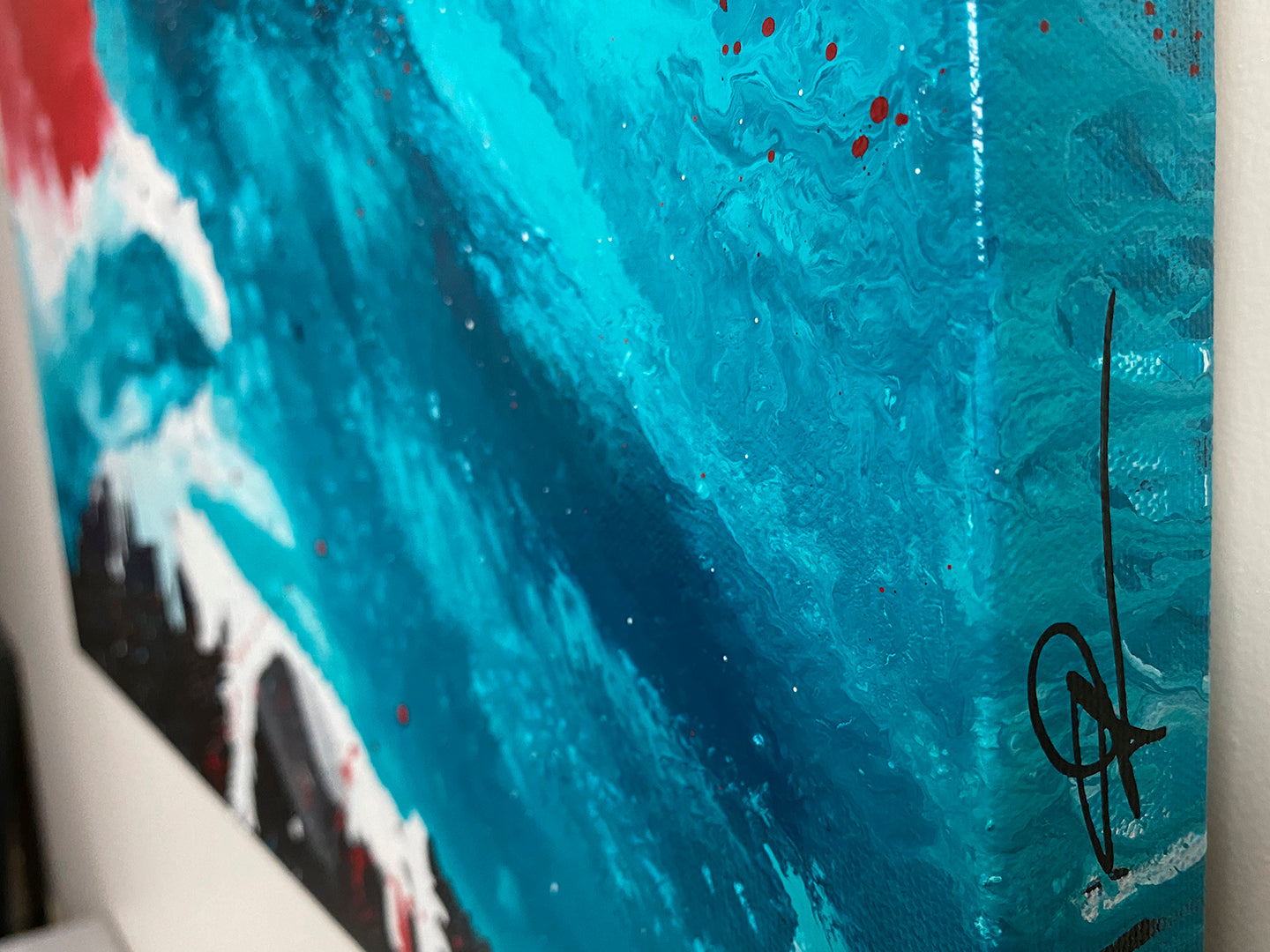 Abstract, expressionism, acrylic painting close-up showing signature on the canvas edge. Volatile interactions of black, dark blue, turquoise, bright red and white